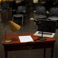 Image of a speaker speaking into a microphone